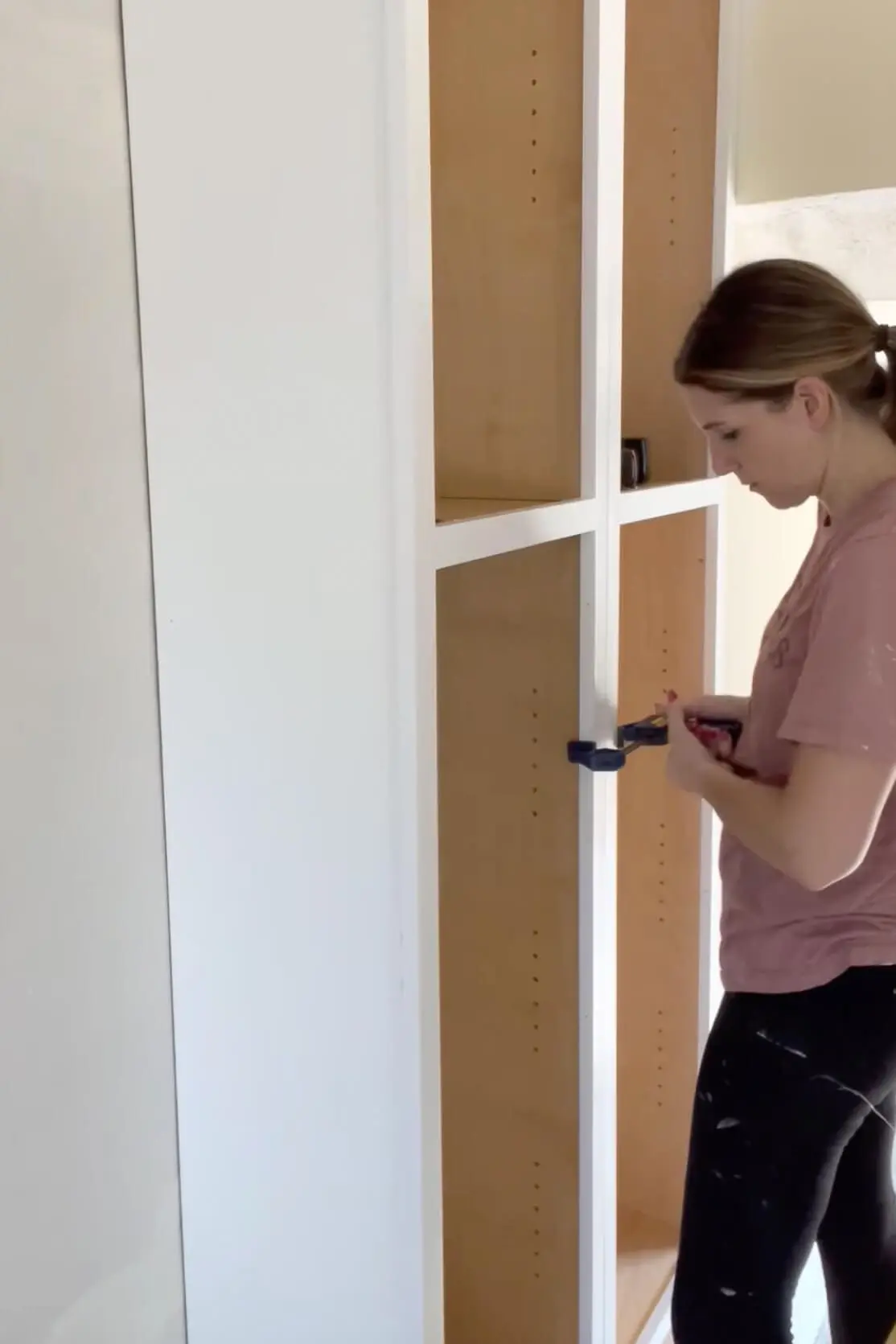 Attaching cabinets together with a clamp.